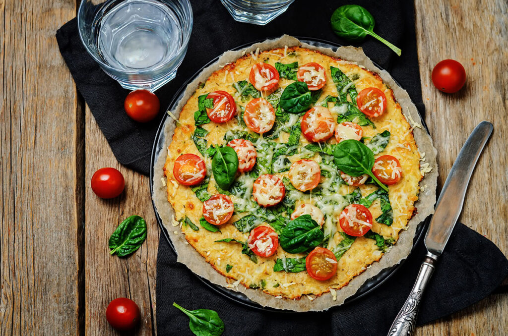 Cauliflower Crust pizza with fresh tomatoes and baby spinach