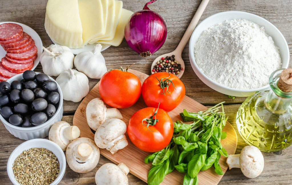 Ingredients for perfect pizza on a wooden background