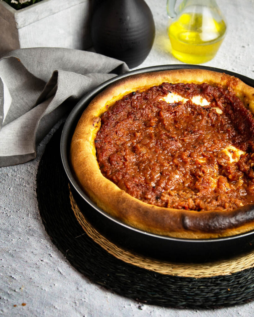 Top view of a deep dish pizza straight out of the oven