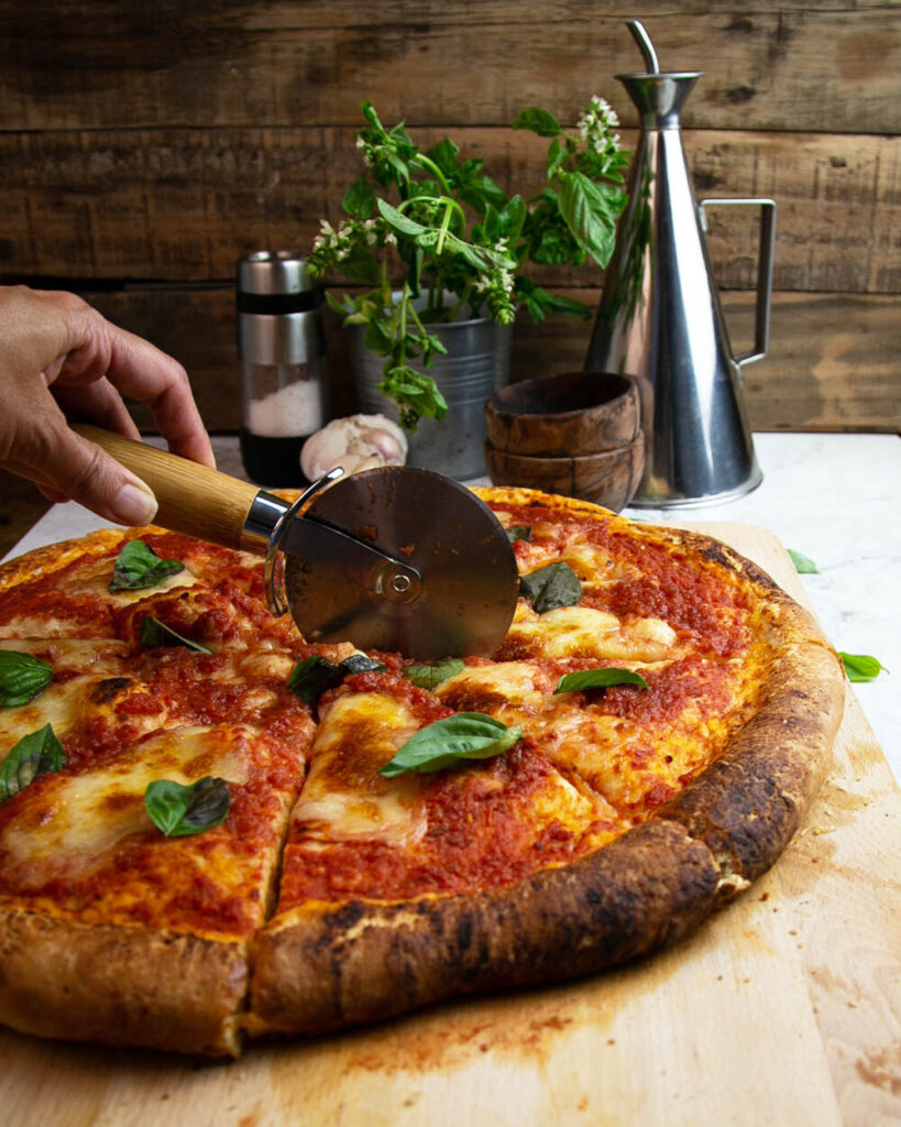 Slicing a classic Margherita pizza for the family