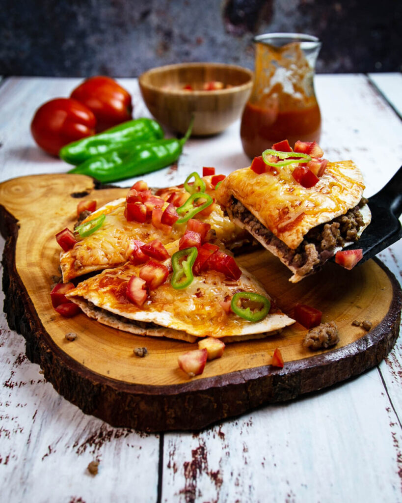 Freshly cooked and sliced Mexican pizza recipe on a wood board