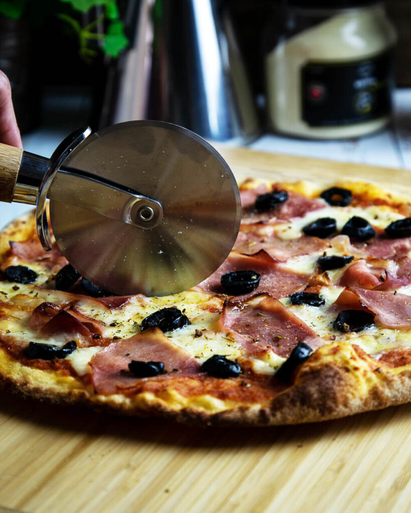 Slicing the very thin crust Romana tonda pizza