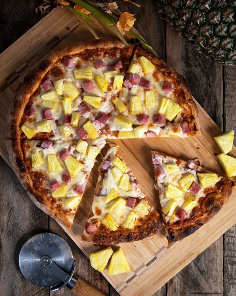 Top view of a sliced Hawaiian pizza ready to eat.