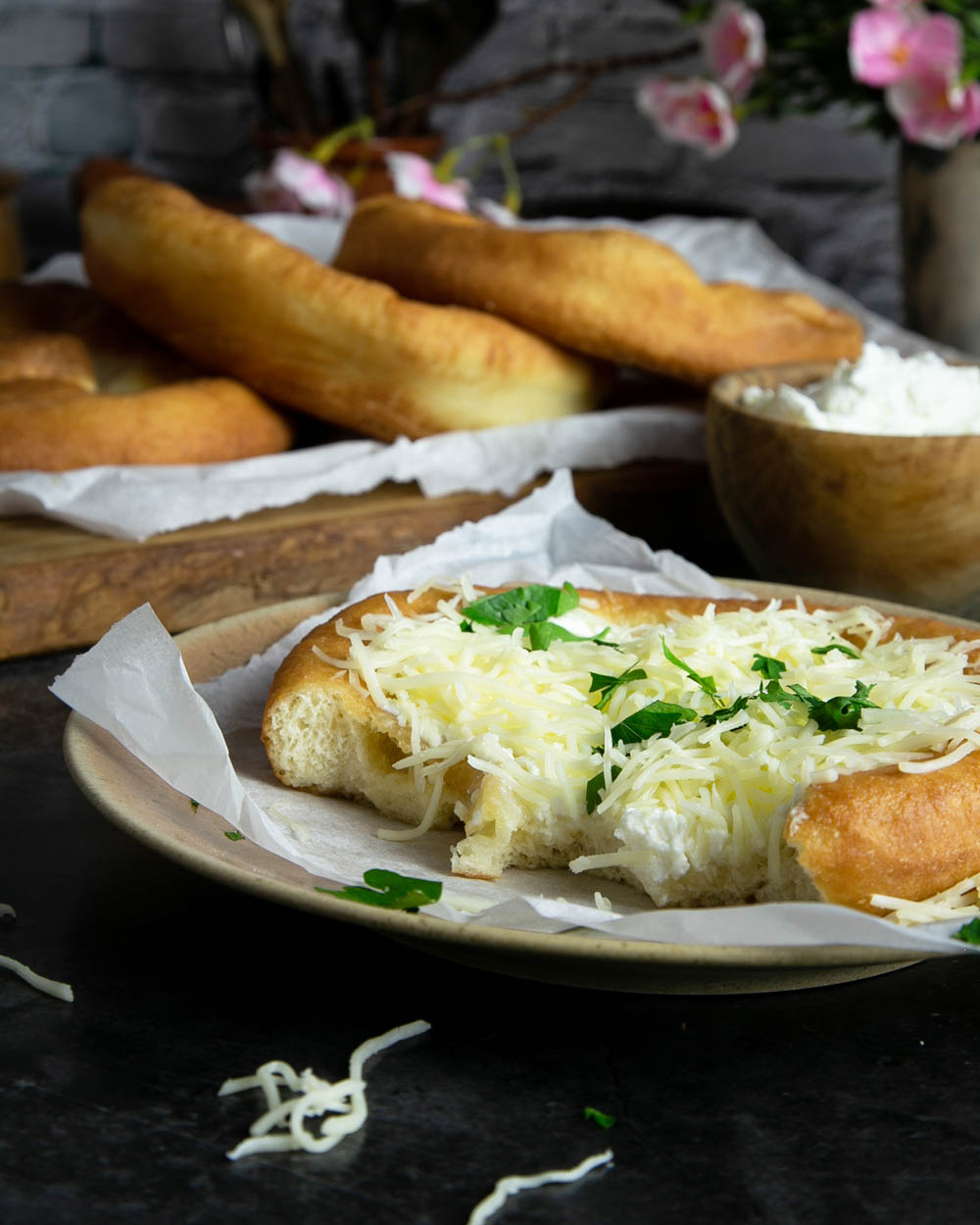 Half eaten Langos topped with the Hungarian traditional sour cream and cheese.