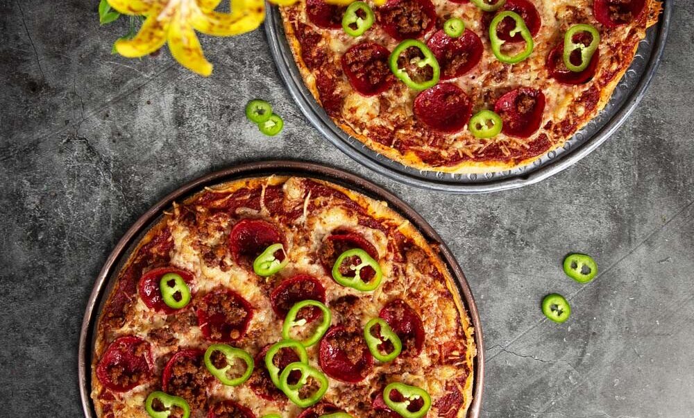 Top view of our St Louis style pizza. Topped with pepperoni, sausage and jalapeños.