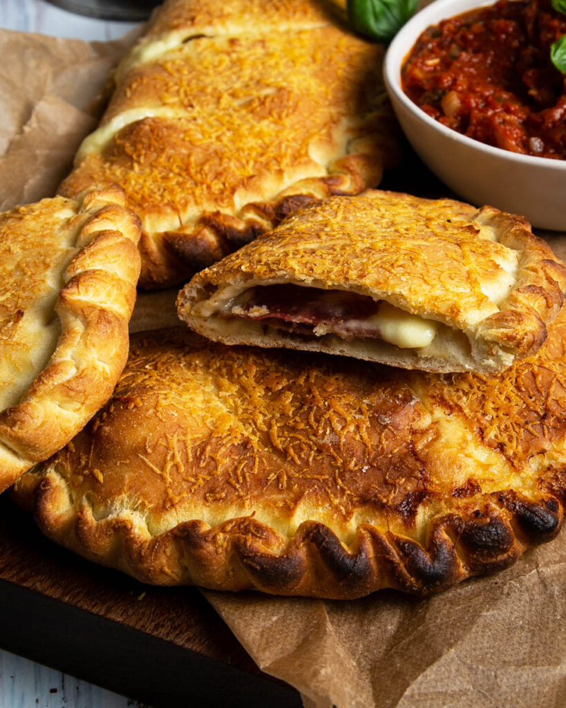 Close up view of a meat filled calzone on parchment paper