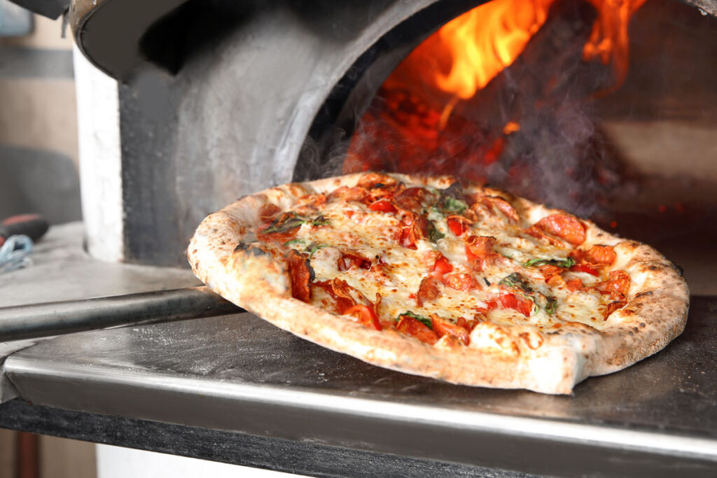 Using a pizza peel to turn pizza for that perfect crust.